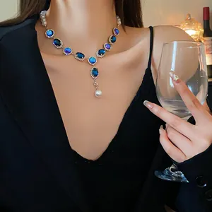 Detail of vintage necklace with blue oval stones and pearl fringe on model
