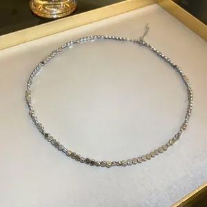 Detailed close-up of a minimalist metallic bead necklace with elegant cold style aesthetic