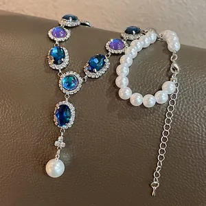 Close-up detail view of vintage jewelry set featuring blue gemstones and white pearls