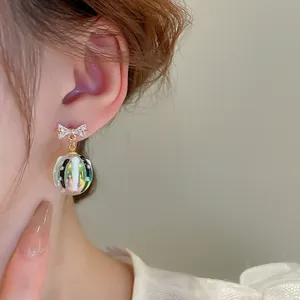 Vue détaillée d'une boucle d'oreille en zircone avec une sphère irisée vibrante