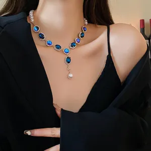 Close-up of a vintage French style blue crystal and pearl tassel necklace on model