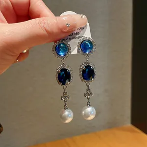 Detail of vintage French style earrings with blue gems, rhinestones and pearls
