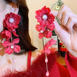 Exaggerated red fabric flower earrings with white pearls and long gold chains