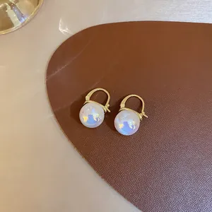 Detailed close-up of retro mermaid pearl earrings with gold-plated U-shaped clasps.