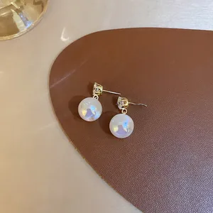Detailed macro shot of elegant mermaid pearl drop earrings with sparkling crystal studs
