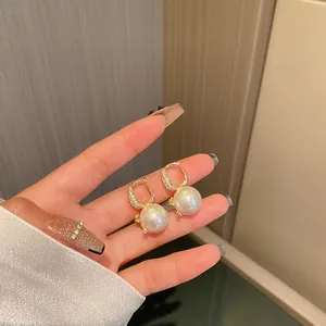 Detailed view of elegant mermaid pearl earrings with gold-plated rhinestone hoops