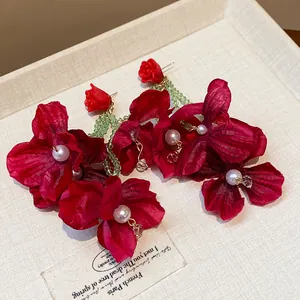 Exaggerated red fabric flower earrings with pearls and elegant green beaded tassels