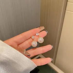 Close-up of elegant mermaid pearl earrings with sparkly cubic zirconia studs