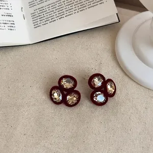Vue détaillée de boucles d'oreilles floquées bordeaux vintage avec des cristaux brillants
