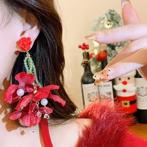 Close-up of elegant red fabric flower earrings with pearls for festive occasions