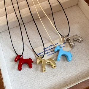 Détails de colliers pendentifs poney vintage colorés dans un écrin à bijoux en bois.