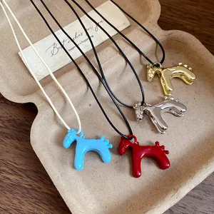 Gros plan des colliers pendentifs poney vintage aux finitions colorées et métal