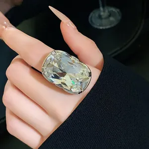 Exaggerated large crystal ring with rectangular cut on model's index finger.