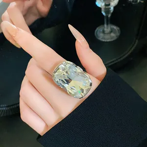 Close-up of a large rectangular crystal statement ring on model's index finger.
