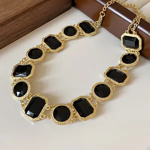 Makroansicht einer Vintage-Goldkette mit geometrischen schwarzen Kristallfacetten