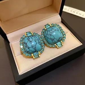 Elegant vintage style turquoise stud earrings with blue rhinestone halo in gold finish