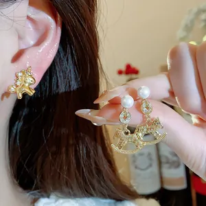 Nahaufnahme von luxuriösen 18k vergoldeten Pferdeohrringen mit Zirkonia und Perlen