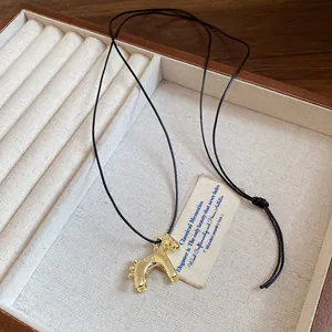 Vue détaillée d'un collier pendentif cheval doré dans un coffret à bijoux en bois