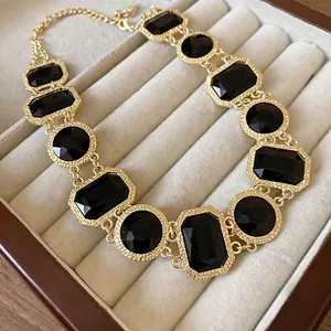 Detailansicht einer Vintage-Goldhalskette mit facettierten schwarzen Steinen
