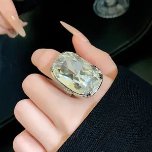 Close-up view of an oversized radiant cut diamond ring on a woman's index finger