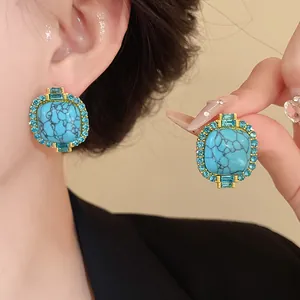 Detail shot of vintage-style stud earrings featuring faux turquoise and blue rhinestones
