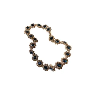 Elegante Vintage-Blumenkette mit tiefblauen Kristallen und funkelnden Pavé-Strasssteinen.