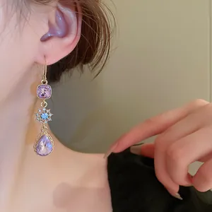 Close-up of elegant purple teardrop zircon earrings with vintage gold hook design