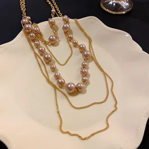 Detalle de collar multicapa vintage francés con perlas y cadenas doradas