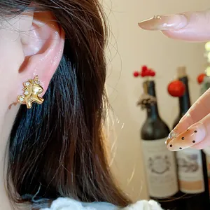 Nahaufnahme eines minimalistischen, 18 Karat vergoldeten Zirkon-Pferde-Ohrsteckers am Ohr