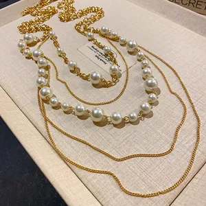 Vista detallada de la elegante cadena de oro de varias capas y perlas de este collar.