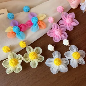 Detailed view of sweet chiffon flower stud earrings with raffia woven centers in four colors