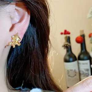 Detailansicht eines filigranen 18k vergoldeten Einhorn-Ohrrings mit glänzenden Zirkonias.