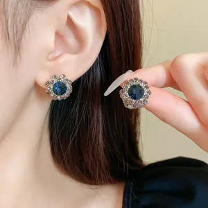 Elegante Vintage-Ohrstecker in Blumenform mit tiefblauem Strassstein in der Nahaufnahme