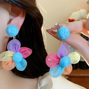 Close-up of colorful chiffon flower earrings with blue raffia top detail and silver needle