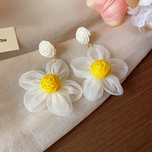 Close-up of sweet chiffon flower earrings with yellow raffia center and mesh petals.