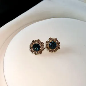 Detail eleganter Blumen-Ohrstecker mit blauen und champagnerfarbenen Kristallen