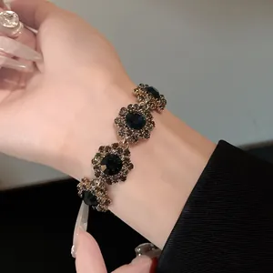 Detailansicht des Vintage-Blumenarmbands mit dunklen Kristallen und glitzernden Strasssteinen