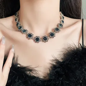 Detailaufnahme einer Vintage-Halskette mit blauen Kristallen am Hals eines Models