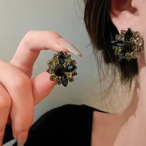 Detailed close-up of vintage floral stud earrings with blue and champagne rhinestones