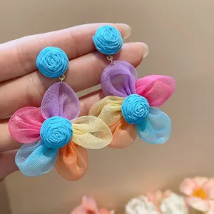 Detail view of multi-color chiffon petal earrings with raffia centers and silver needles