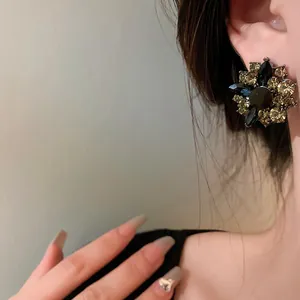 Detailed close-up of vintage flower stud earring with black and champagne crystals