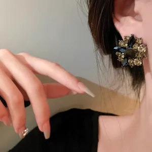 Close-up detail of vintage floral stud earrings featuring multi-colored crystals