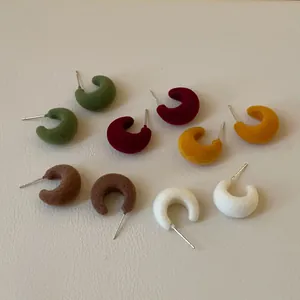 Detail view showing soft flocked texture of C-shaped stud earrings in five colors