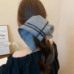 Back view detail of a black and white checkered square scarf hair scrunchie on a ponytail