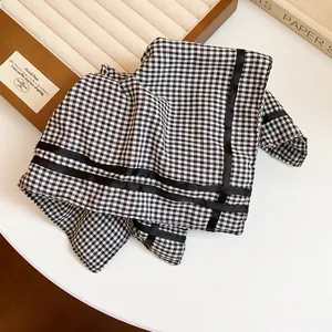 Close-up of black and white gingham scarf hair tie with elegant black ribbon details