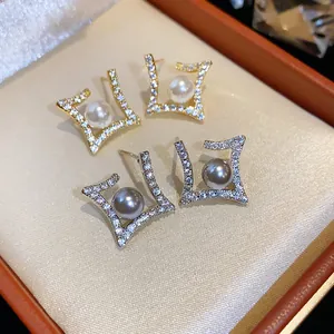 Detail view of elegant rhombus stud earrings with pavé zircons and central pearls.