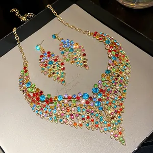 Detailed view of colorful rhinestone leaf necklace and earrings set in gold