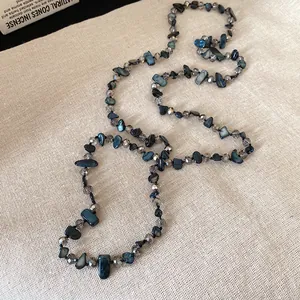 Vue détaillée d'un collier vintage avec coquillages bleus et perles de verre grises