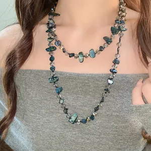 Collier vintage élégant avec perles de verre et de coquillage pour un look unique.