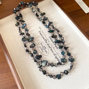 Vue détaillée d'un collier vintage avec des coquillages bleus et des perles de verre